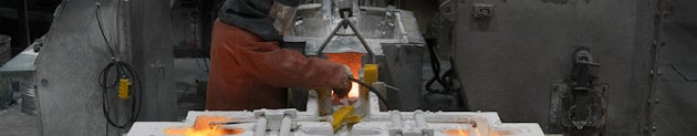 Mand, der arbejder med flydende aluminium i et støberi