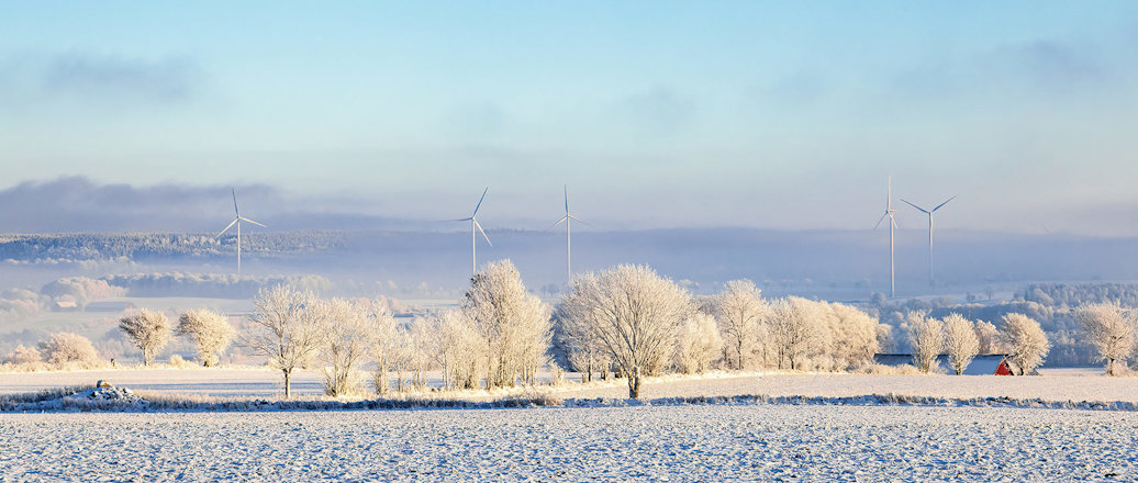A field of snow with windmills in the distance