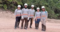 a group of people wearing hardhats and standing on a dirt road